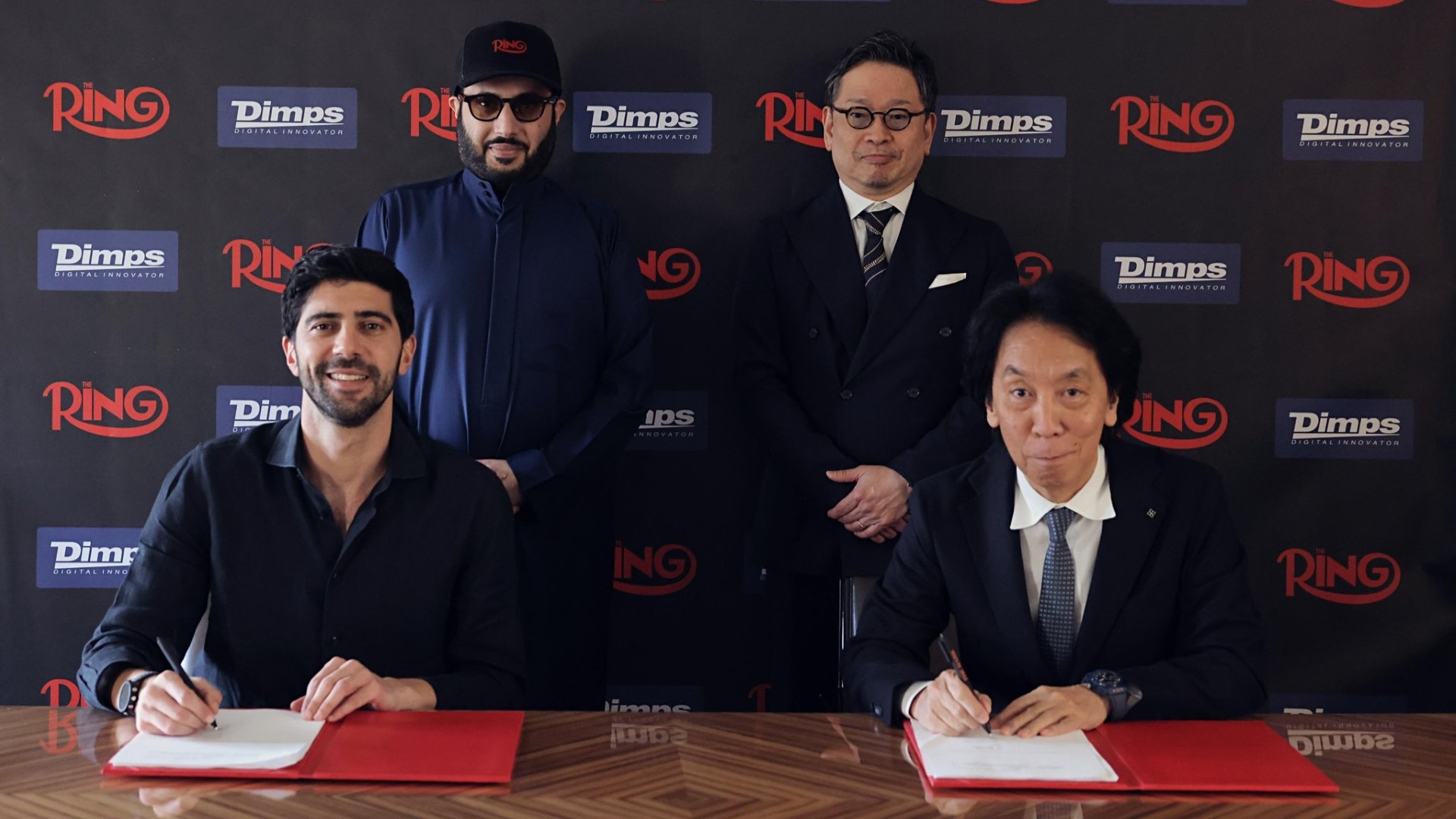 Takashi Nishiyama, head of Dimps, and Turki Alalshikh, head of The Ring Magazine, signing off on their partnership for a new, original boxing video game.